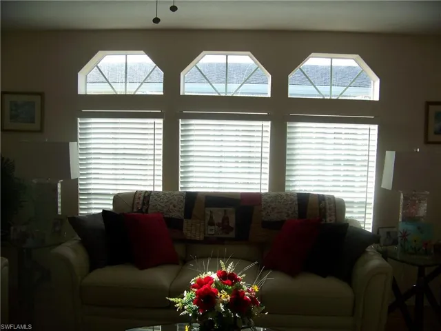 Beautiful transom windows above single hung windows behind couch/sofa in living room