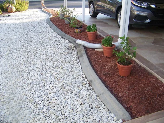 Concrete curbing gardens with shared crushed rock decor with neighbor for a nice clean look.