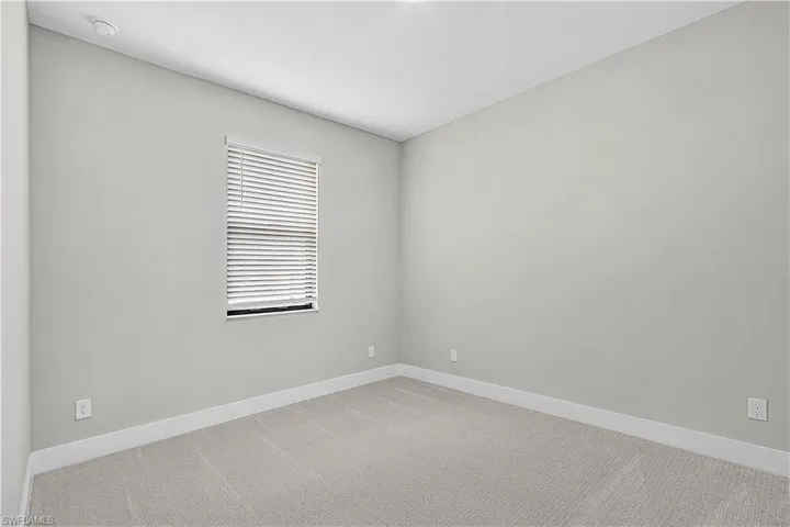 Spare room with light carpet and baseboards