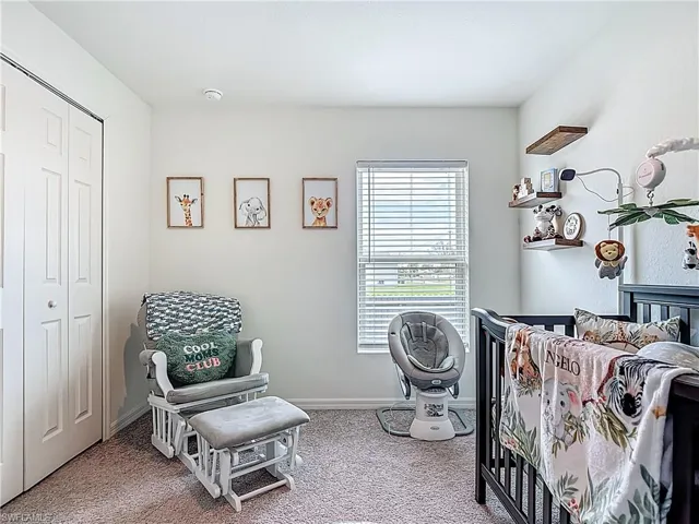 Carpeted bedroom with baseboards and a closet