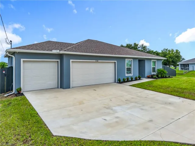 Ranch-style home featuring a shingled roof, stucco siding, a garage, and concrete driveway
