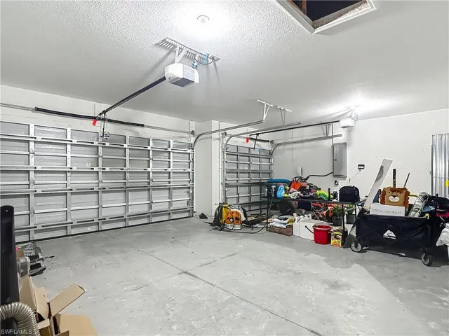 Garage featuring electric panel and a garage door opener