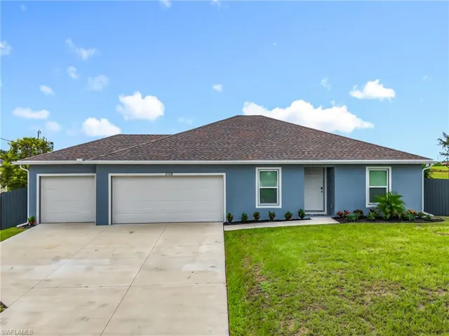 Ranch-style house featuring a garage, a shingled roof, driveway, and stucco siding