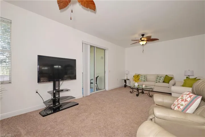 Living room with ceiling fan and carpet flooring
