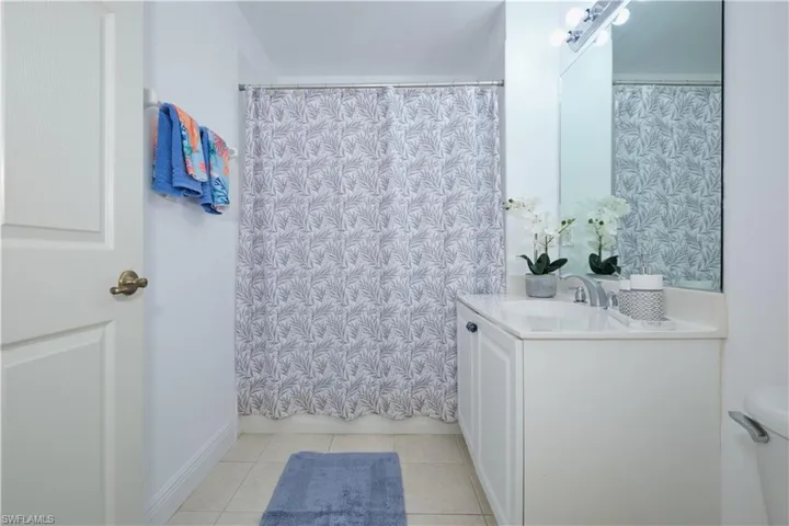 Bathroom with vanity with extensive cabinet space, tile flooring, and toilet