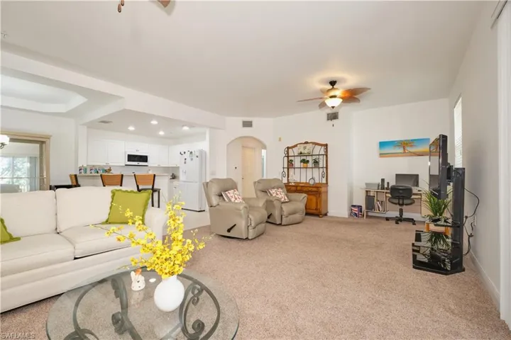 Carpeted living room with ceiling fan