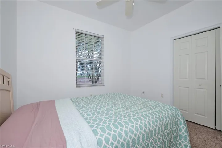 Bedroom with a closet, carpet, and ceiling fan