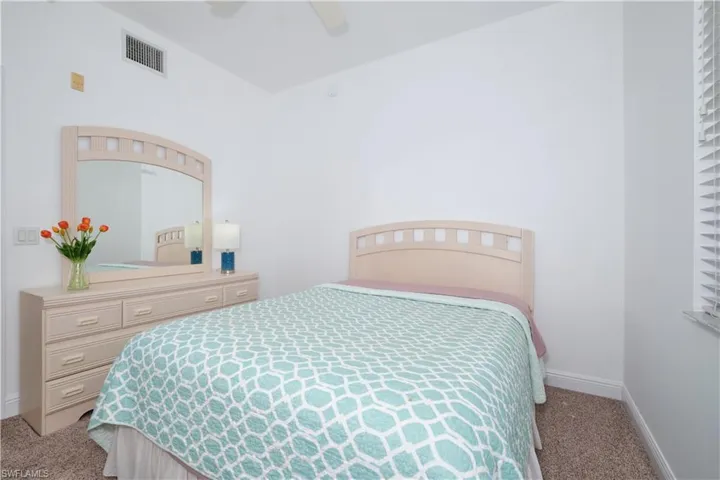Carpeted bedroom featuring ceiling fan
