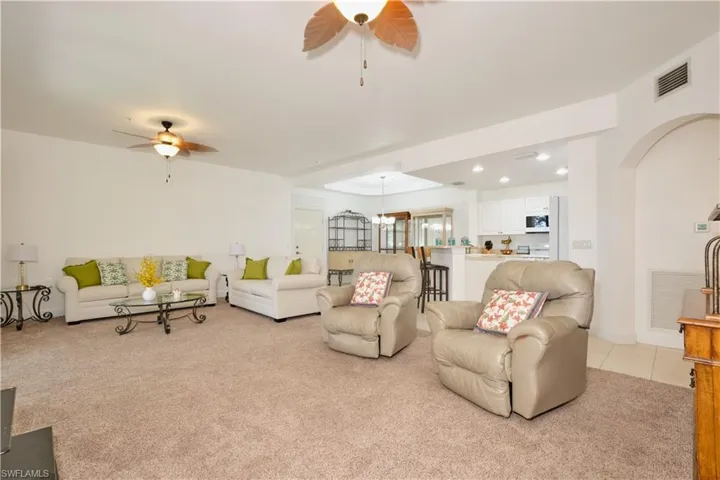 Carpeted living room featuring ceiling fan