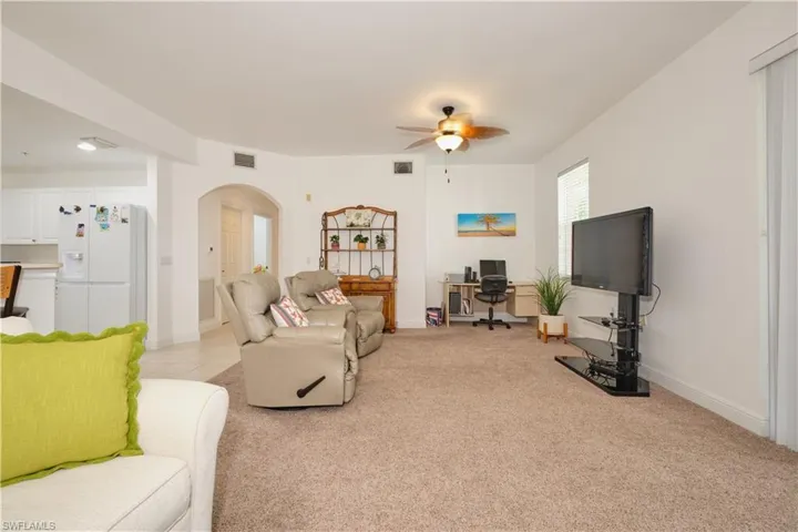 Living room with light colored carpet and ceiling fan