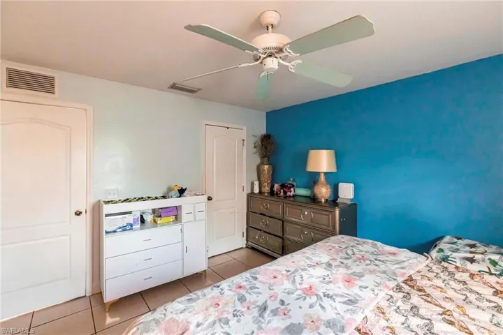 Bedroom with ceiling fan and light tile patterned floors