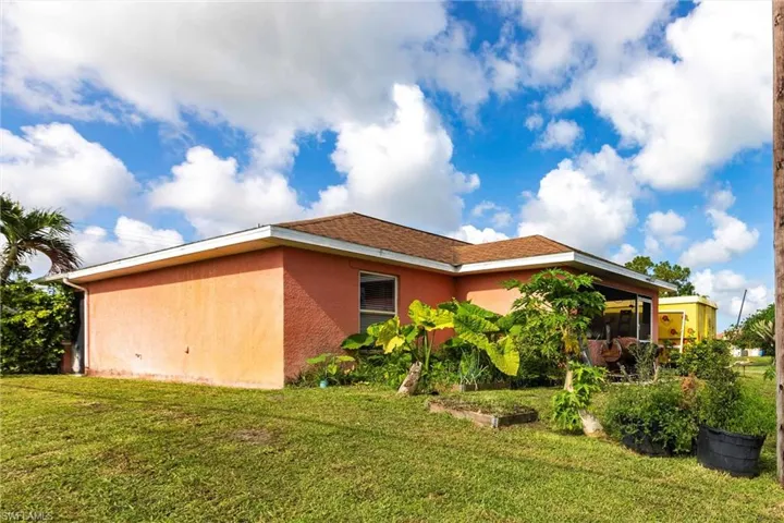 View of home's exterior featuring stucco siding, a yard, and a sunroom