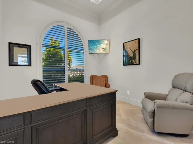 Architectural arched window with plantation shutters, crown molding, light neutral wall tones, elegant baseboards, and light-toned flooring