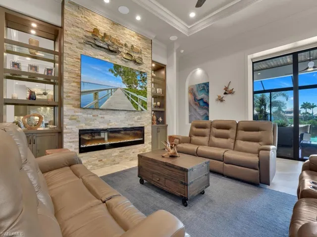 Living area featuring a floor-to-ceiling stacked stone accent wall with an integrated linear electric fireplace