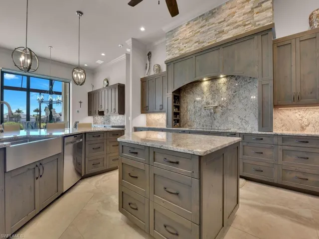 Kitchen featuring a central island with countertop, wood-finish cabinetry, stainless steel farmhouse sink, and integrated stainless steel dishwasher