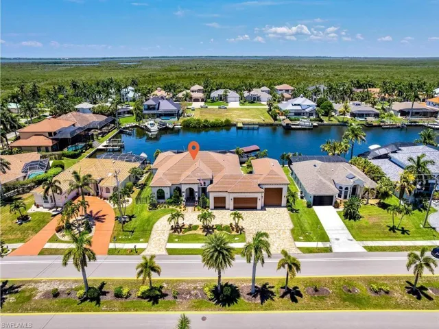 Waterfront residence with a tile roof and attached garages