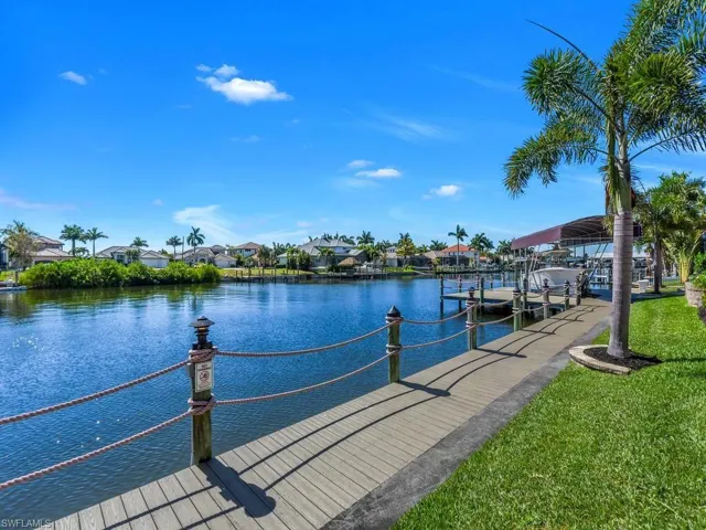 Waterfront access featuring a composite deck with rope railing and decorative bollard lighting