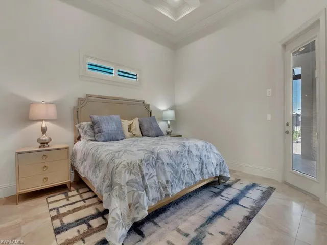 Tile flooring extending into a private outdoor area, featuring a decorative coffered ceiling and a high transom window