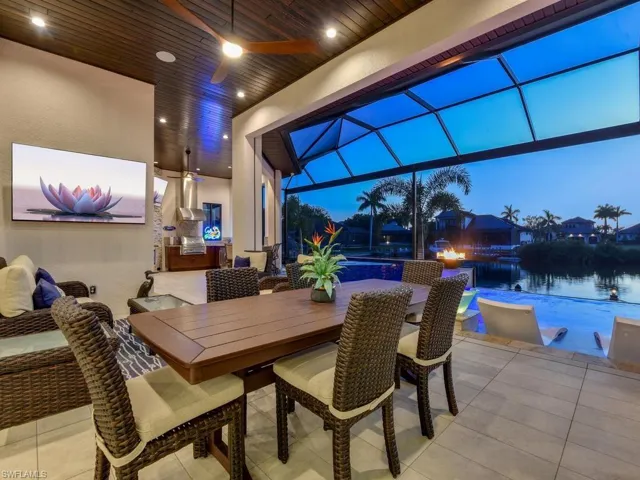 Expansive outdoor living area featuring a wood-finish plank ceiling, recessed lighting, and a large format television