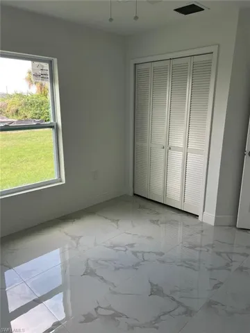 Unfurnished bedroom featuring a closet and light tile floors