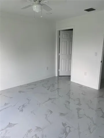 Tiled empty room with ceiling fan