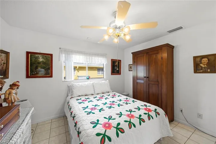 Bedroom with ceiling fan and light tile patterned flooring