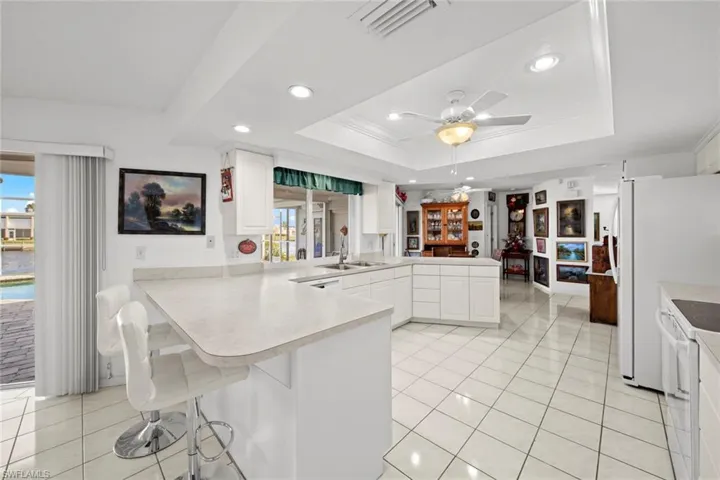 Kitchen featuring white cabinets, a healthy amount of sunlight, and kitchen peninsula
