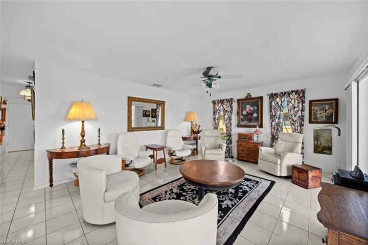Living room with ceiling fan and light tile patterned flooring