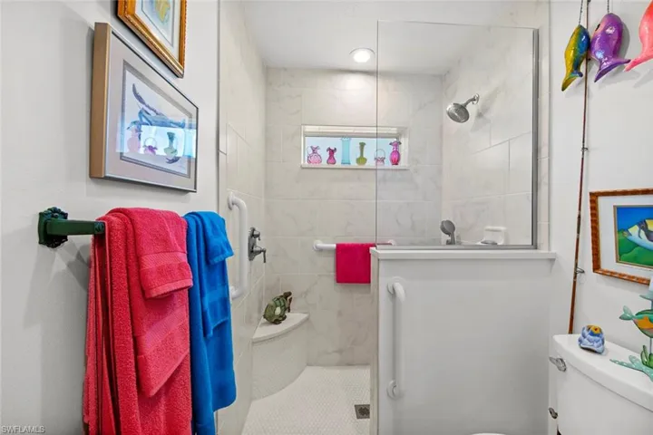 Bathroom featuring a tile shower and toilet