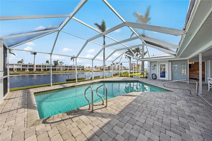 View of pool featuring a patio area, a lanai, and a water view