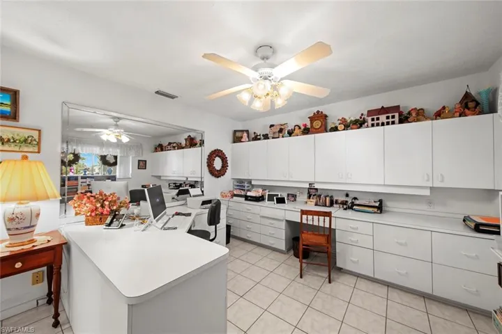 Kitchen with ceiling fan, light tile patterned flooring, and white cabinetry