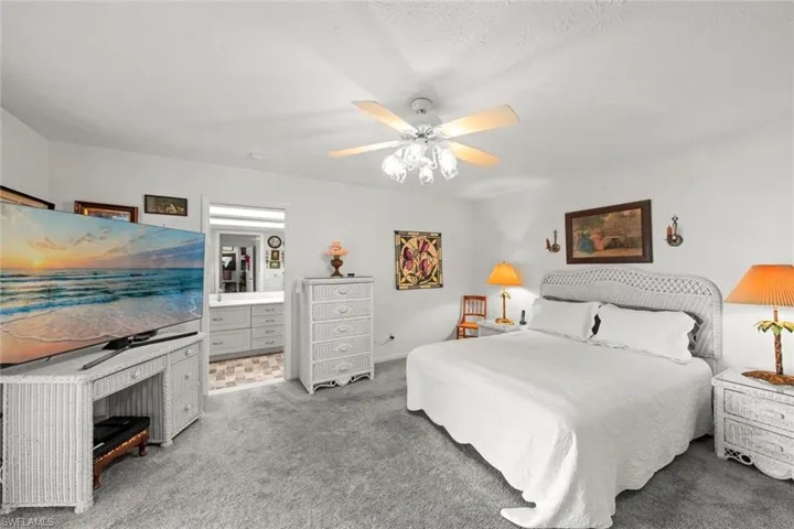 Bedroom with ceiling fan, carpet floors, and a textured ceiling