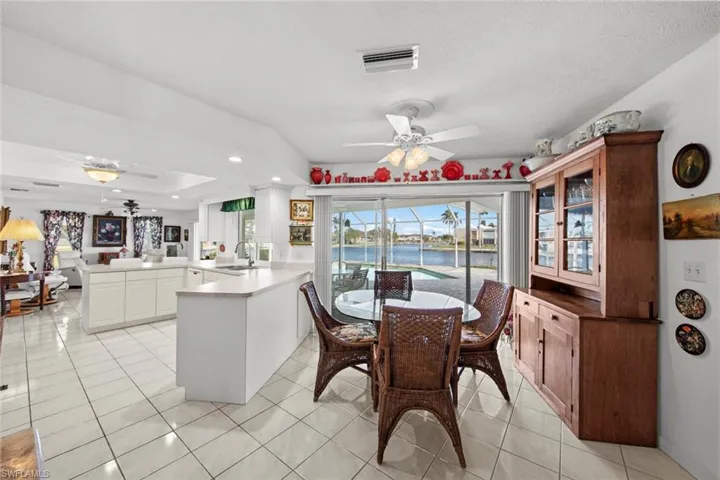 Dining space featuring ceiling fan, a water view, light tile patterned floors, and sink