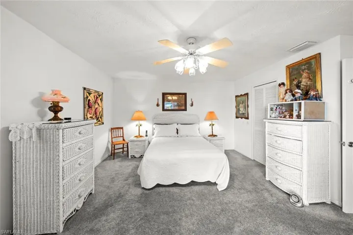 Carpeted bedroom featuring a textured ceiling, a closet, and ceiling fan