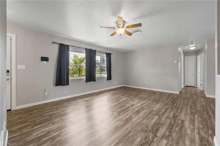 Unfurnished living room featuring dark wood finished floors and a ceiling fan