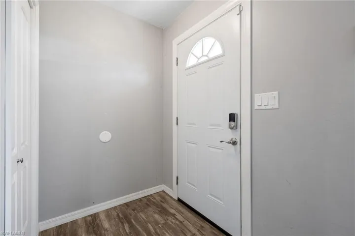 Entryway featuring baseboards and dark wood-style floors