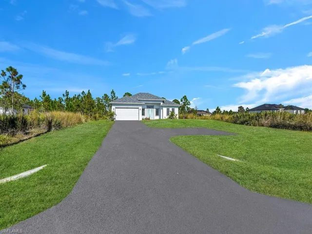 Single story home with a garage, a front lawn  and 2 detached garage.