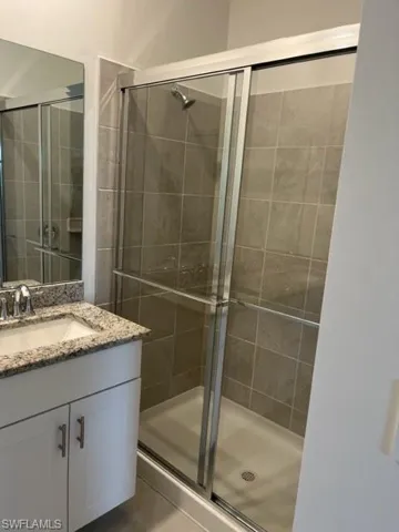 Bathroom featuring vanity and a shower stall