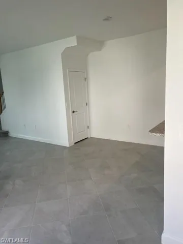 Empty room featuring baseboards and stairway