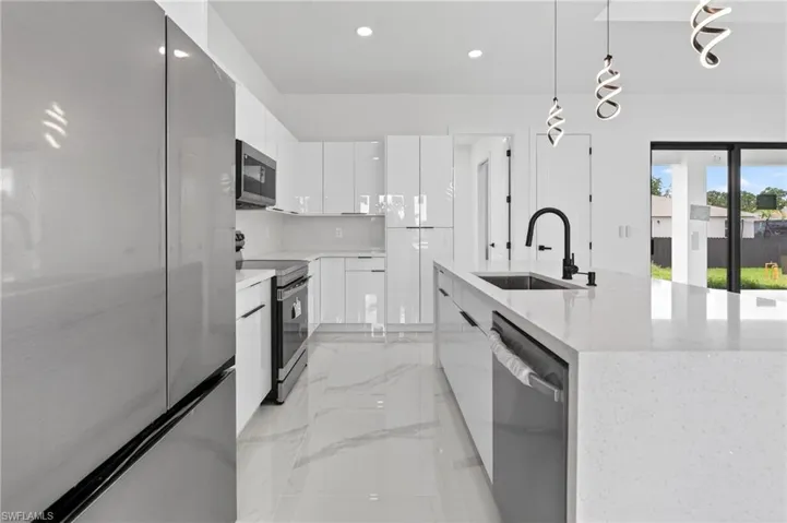 Contemporary kitchen with a large center island, white gloss cabinetry, stainless steel appliances, a black gooseneck faucet, and marble-look floor tiling