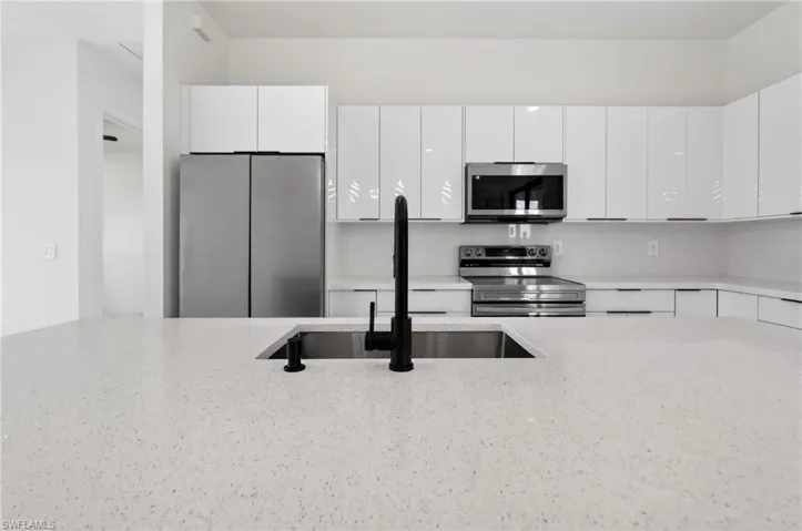 Expansive kitchen island featuring a deep undermount sink with a matte black faucet