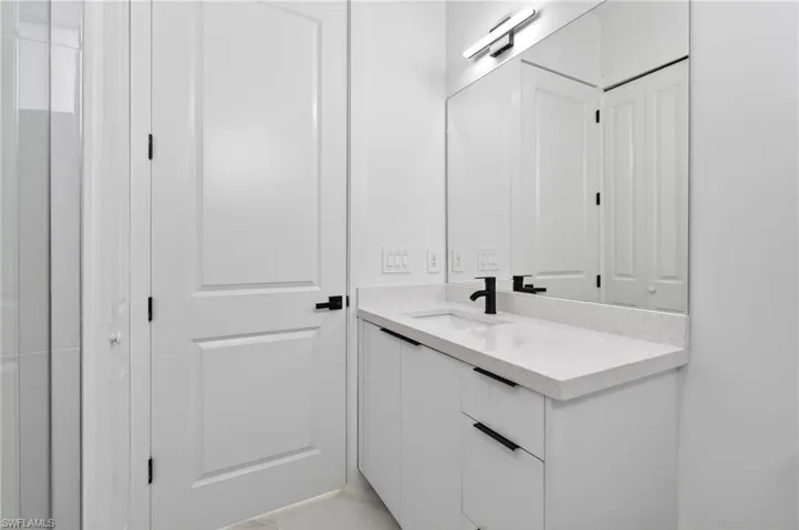 Modern bathroom vanity featuring a quartz-finish countertop and integrated sink