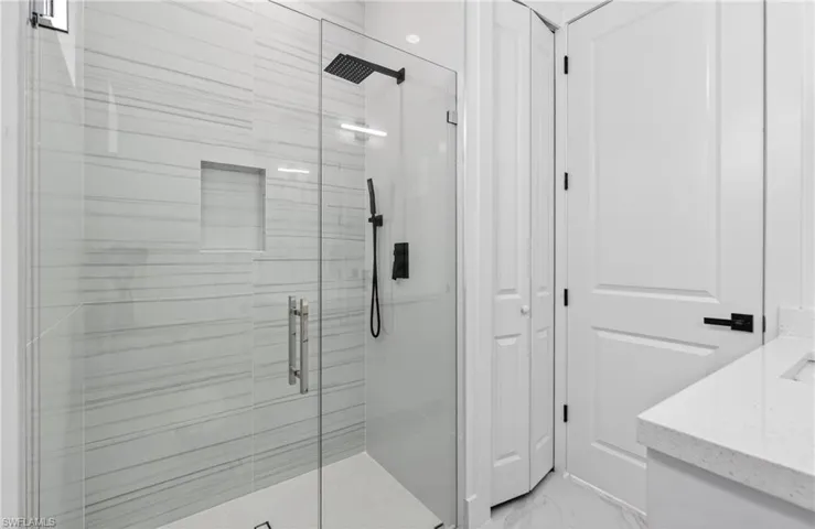 Contemporary shower enclosure with clear glass paneling and a built-in shower niche