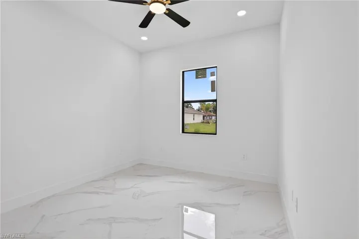 Bright interior space featuring large format tile flooring and a black framed window