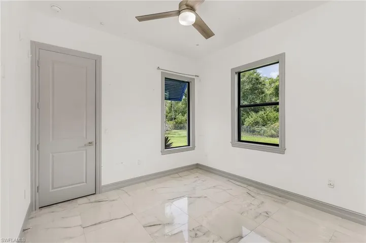 Spare room with ceiling fan and light tile floors