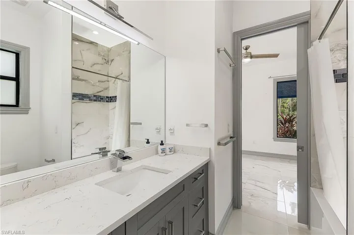 Full bathroom featuring tile floors, shower / bath combination with curtain, large vanity, and toilet