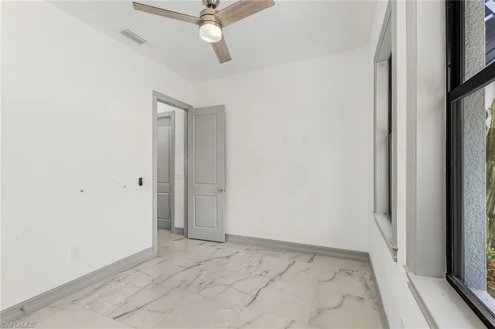 Spare room featuring ceiling fan and light tile floors