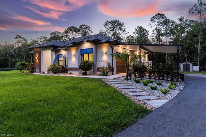View of front of house with a yard and a carport