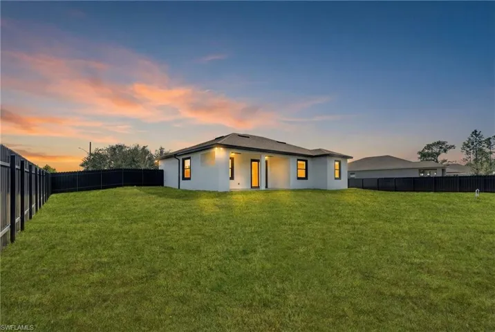Back of property featuring a fenced backyard, stucco siding, and a patio