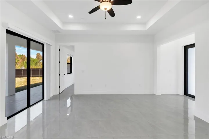 Unfurnished room with a ceiling fan, a tray ceiling, and recessed lighting